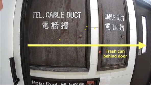 Arrow showing the trash bin behind the stairwell door