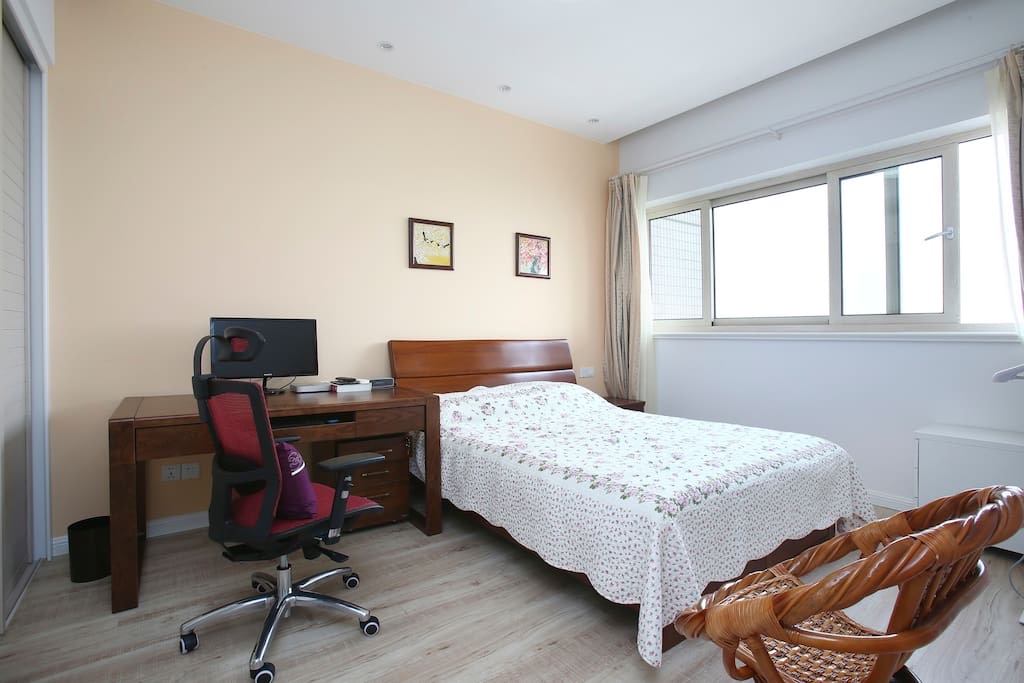 Bedroom with desk and city-facing windows